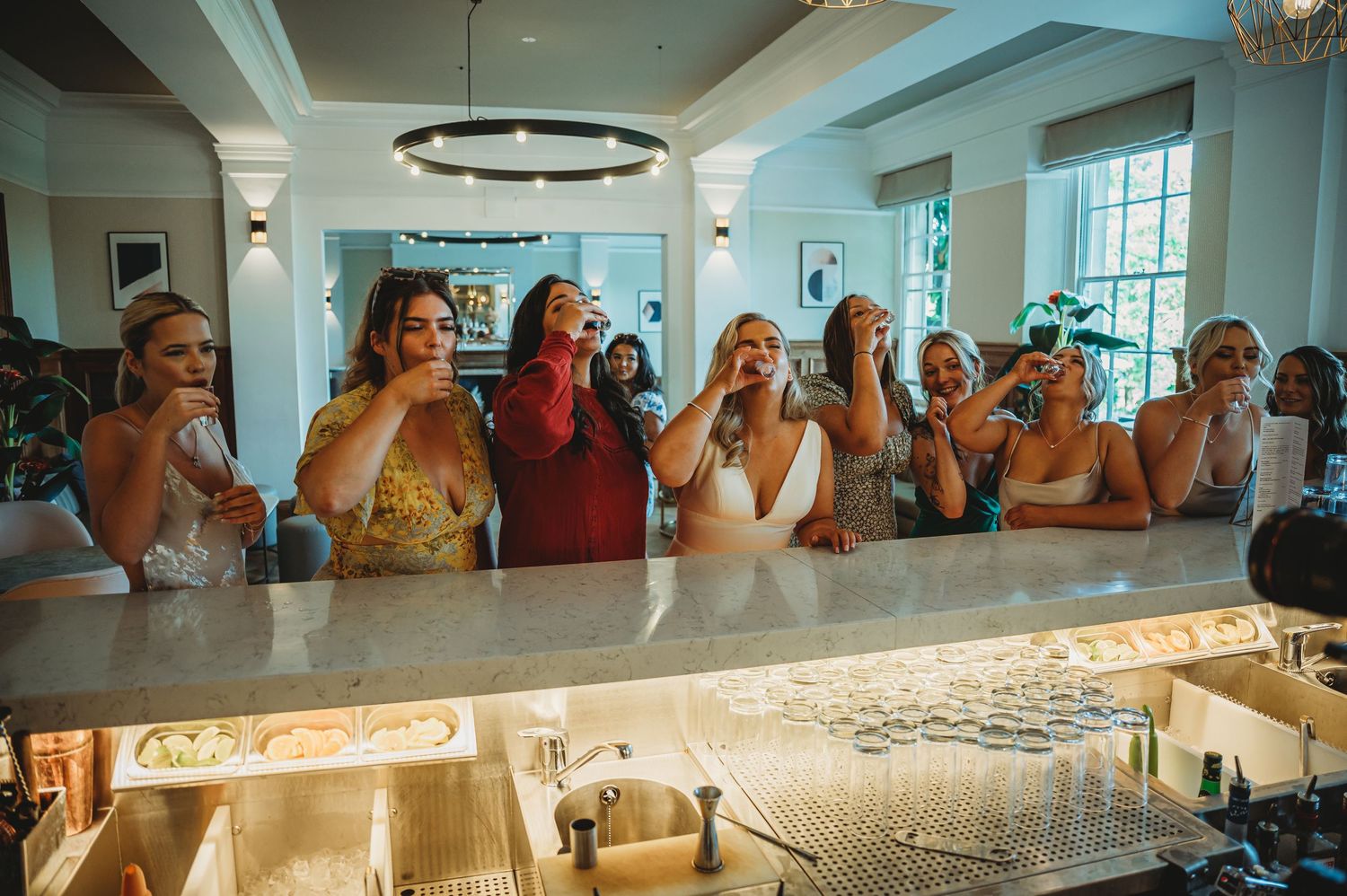 Group of guests gathered at an illuminated bar counter.