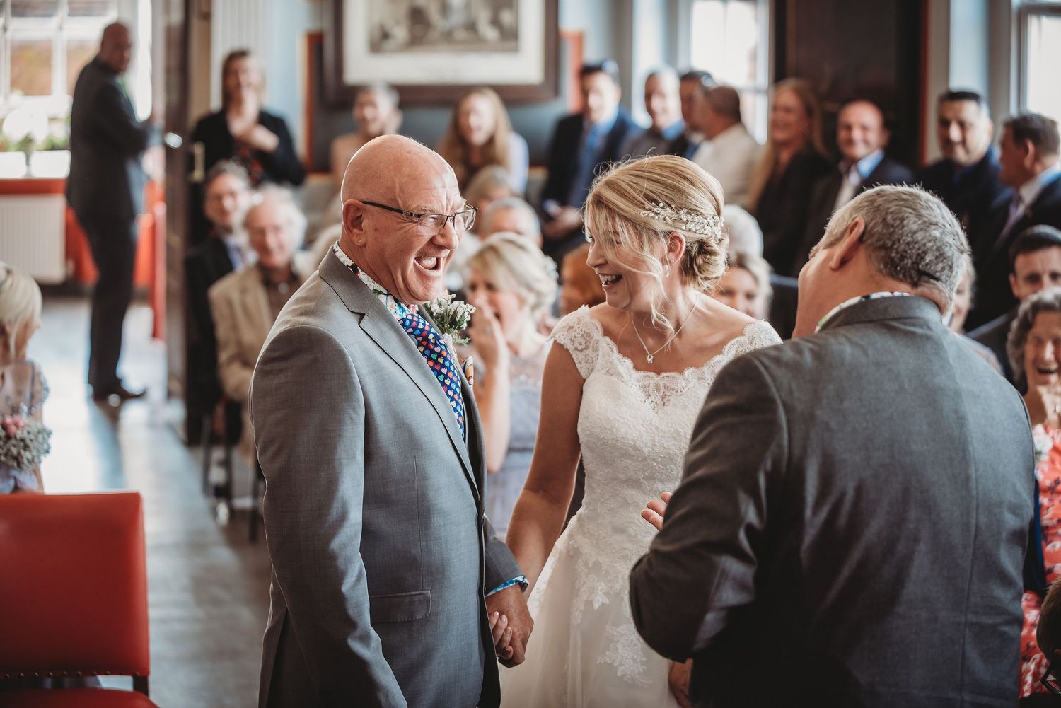 Elegant wedding celebration in an indoor venue with guests gathered around in formal attire.