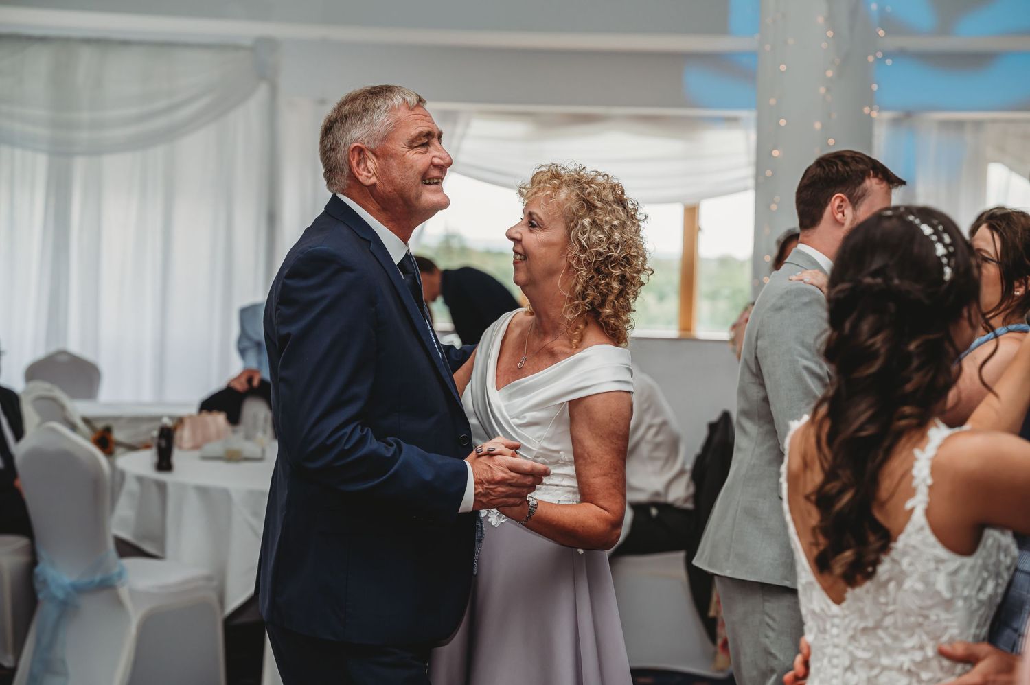 A couple shares a special moment together while dancing at an elegantly decorated wedding reception.
