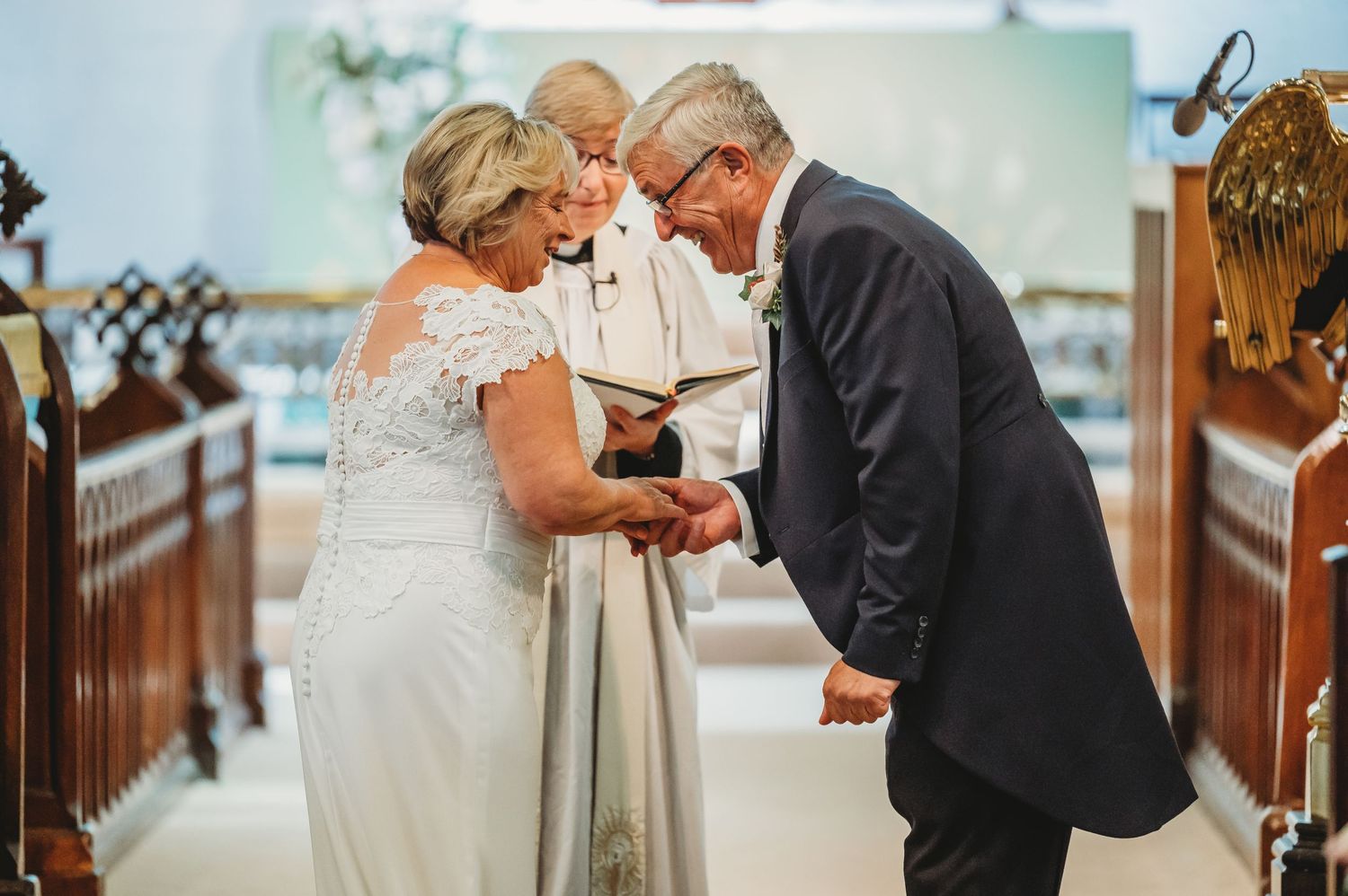 A tender wedding ceremony moment captured at the altar as a couple shares an emotional exchange with their officiant.