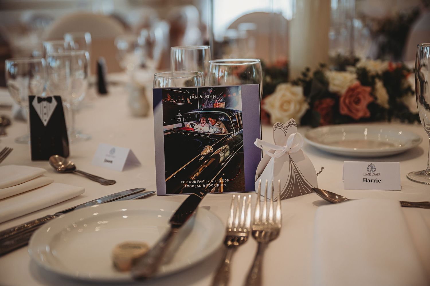 Wedding table setting with elegant place cards, silverware, and a creative bowling-themed miniature display centerpiece.