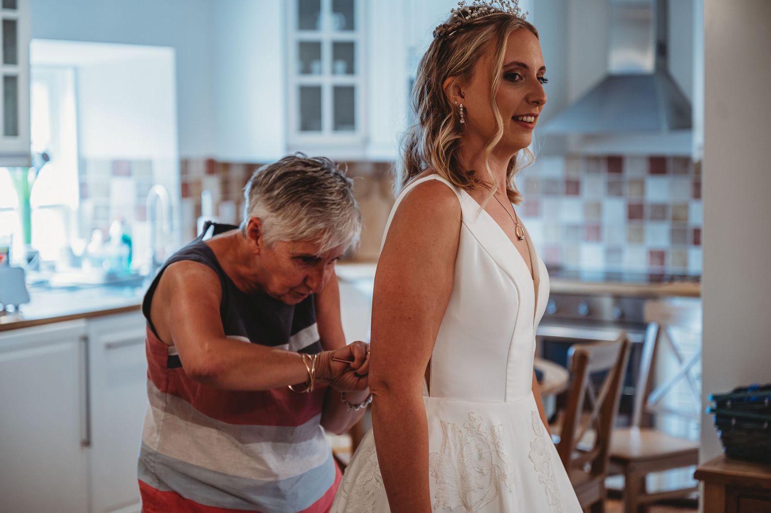 A wedding dress fitting session in a bright modern kitchen with natural lighting.