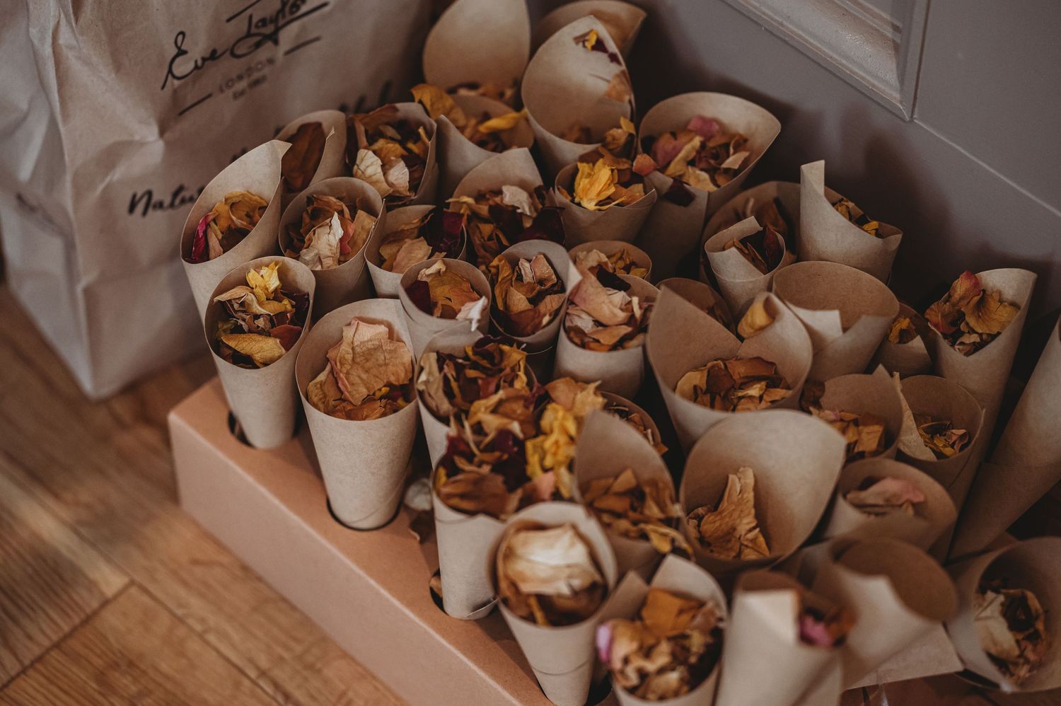 A box filled with dessert cones containing various sweet treats and toppings arranged neatly in rows.