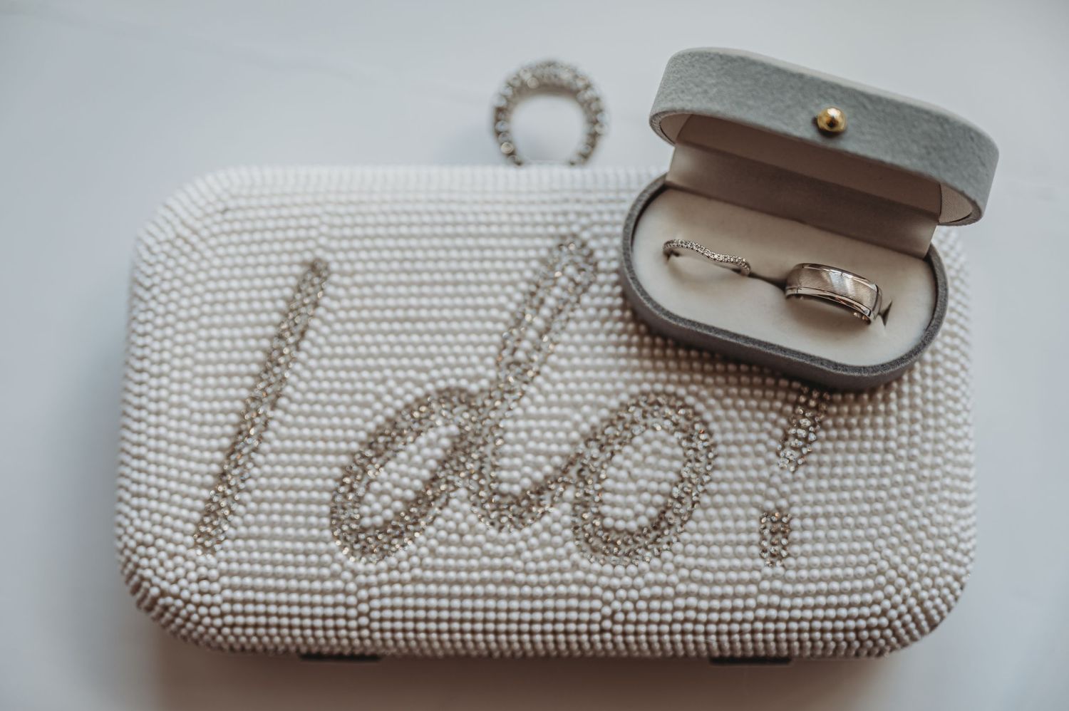 Pearl beaded wedding clutch with 'I do' text and engagement ring box.