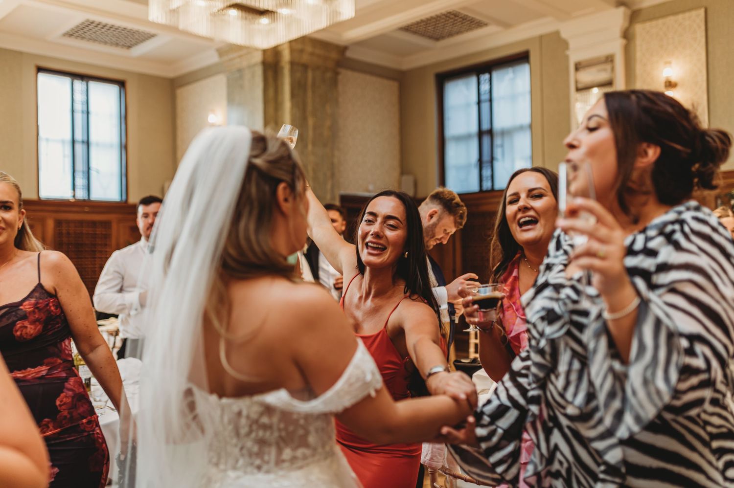 Wedding party dancing and celebrating on dance floor.