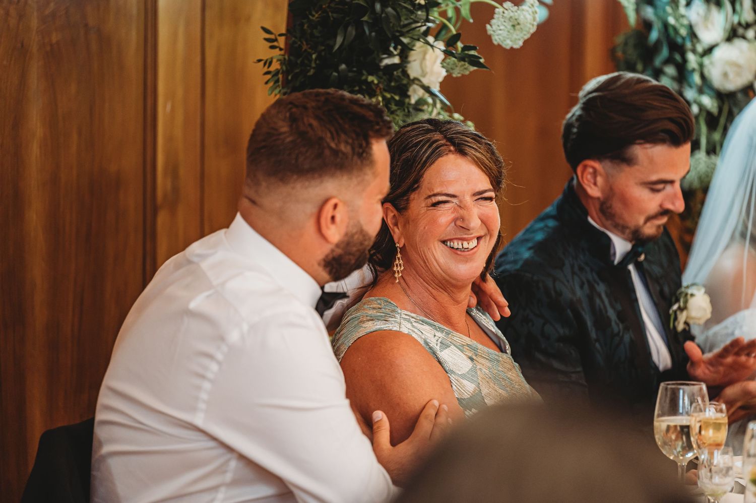 Wedding guests share laughs during reception dinner conversations.