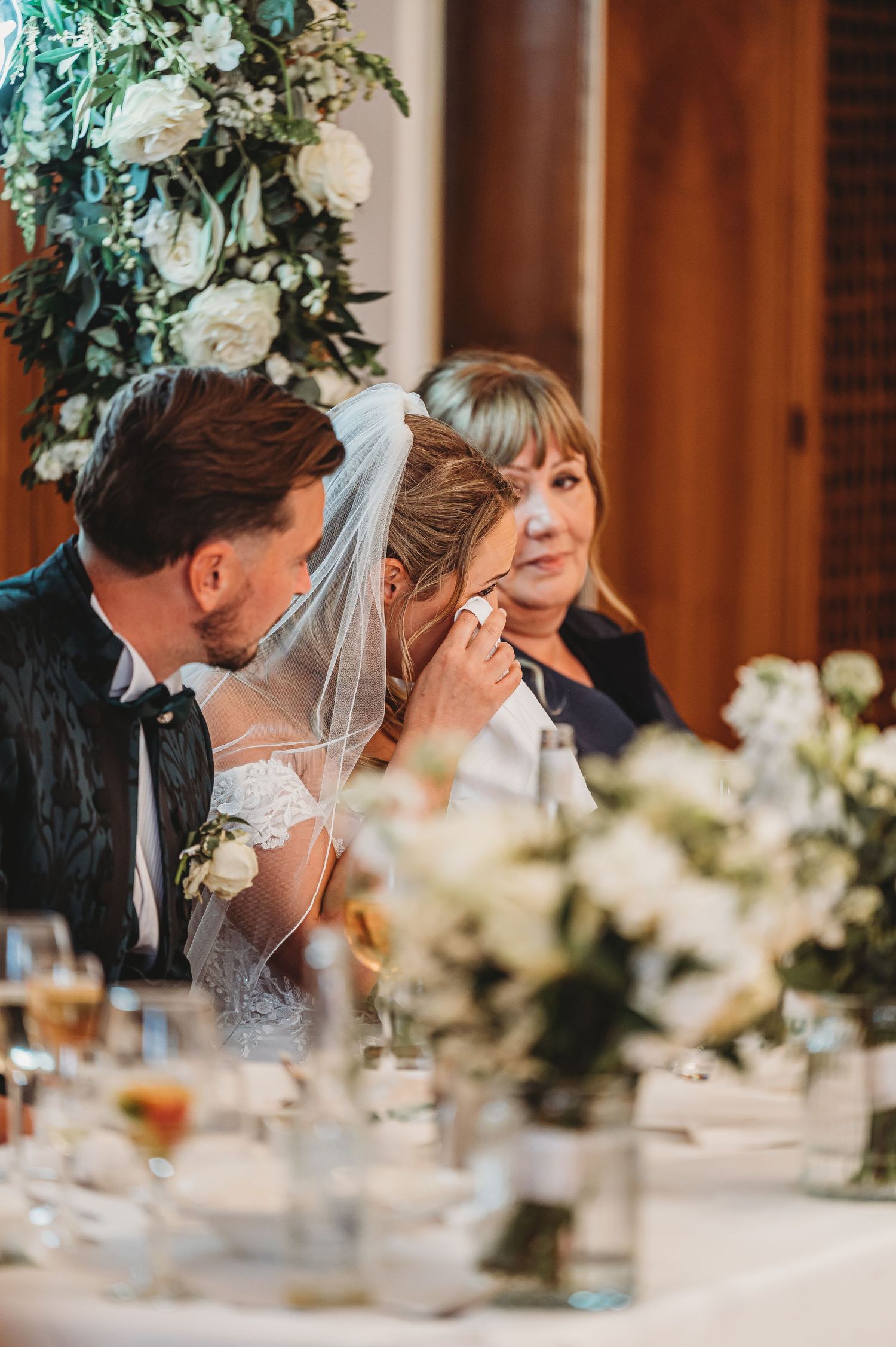 Intimate moment captured during wedding reception with white floral decorations.