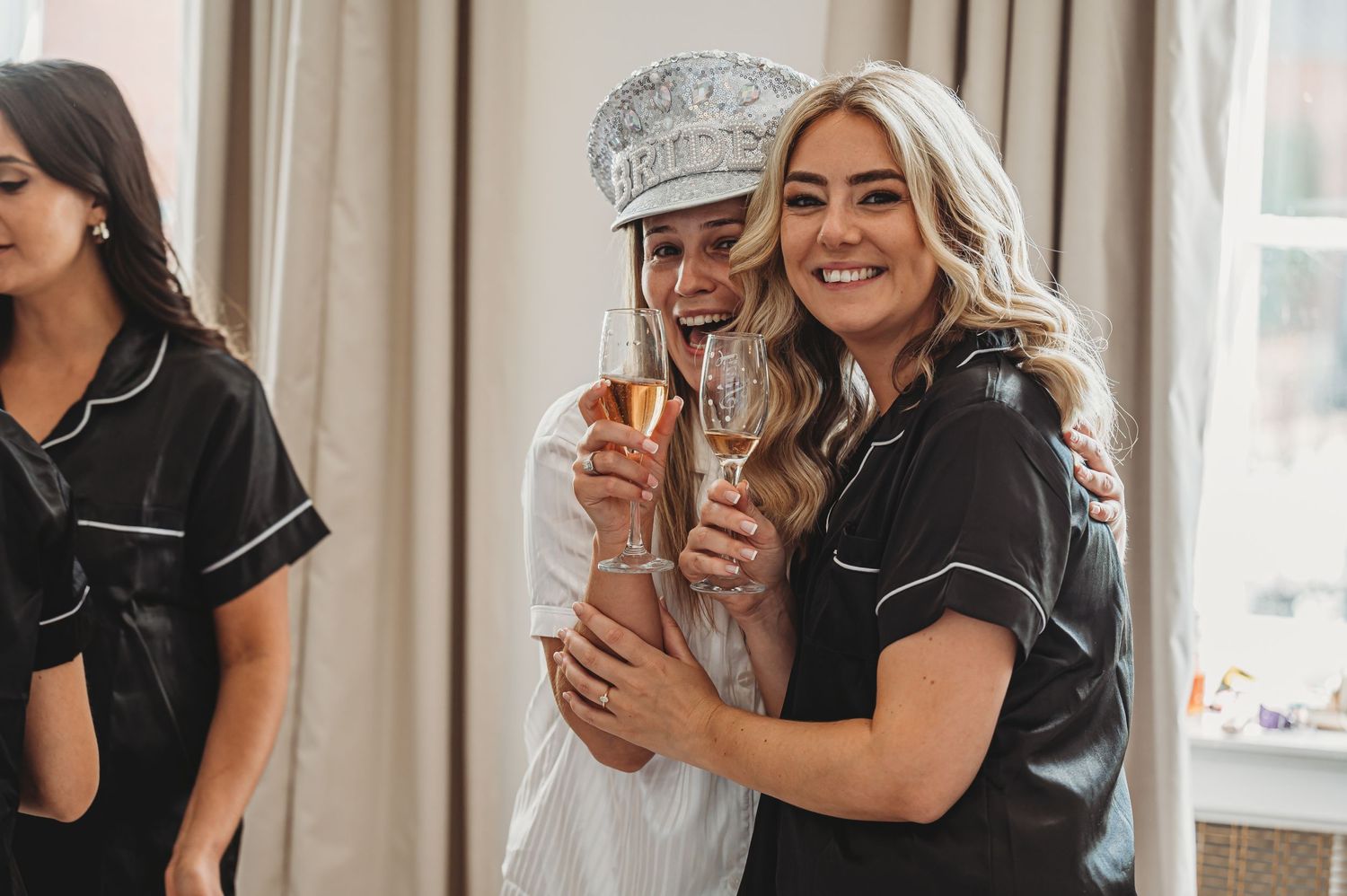 Wedding party members in matching robes celebrating with champagne.