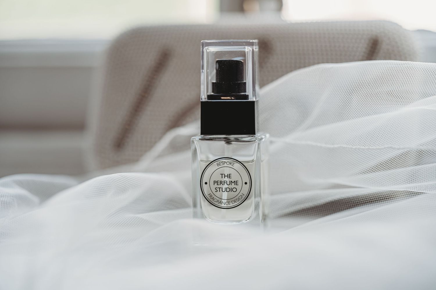 Wedding perfume bottle nestled in white tulle fabric.