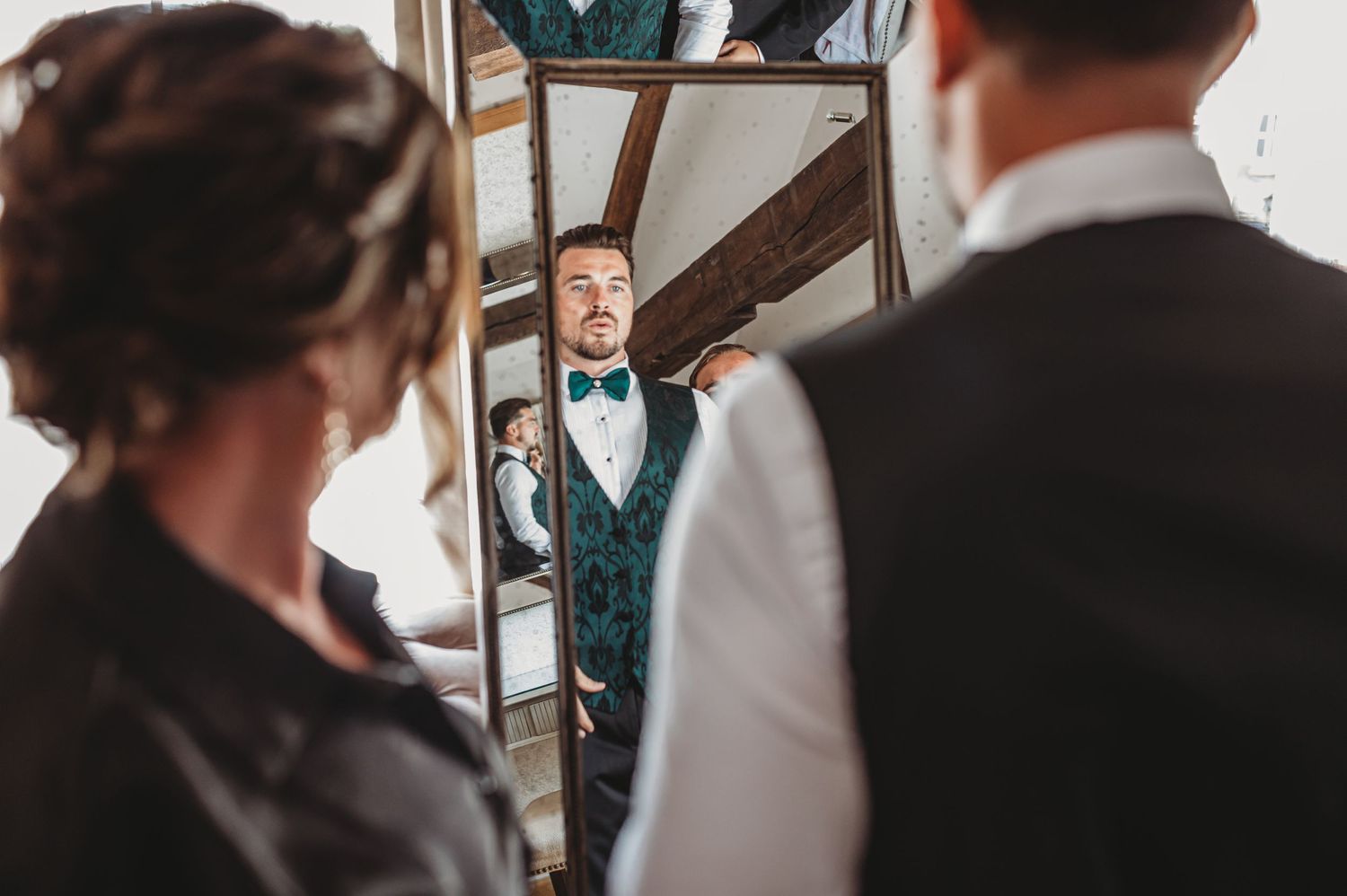 Wedding preparation scene reflected in mirror with formal attire.