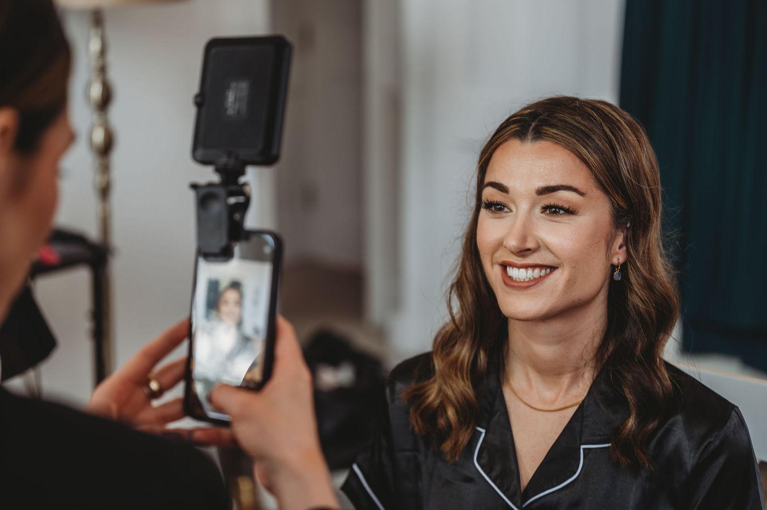 Behind-the-scenes moment of wedding preparation being recorded on a smartphone.