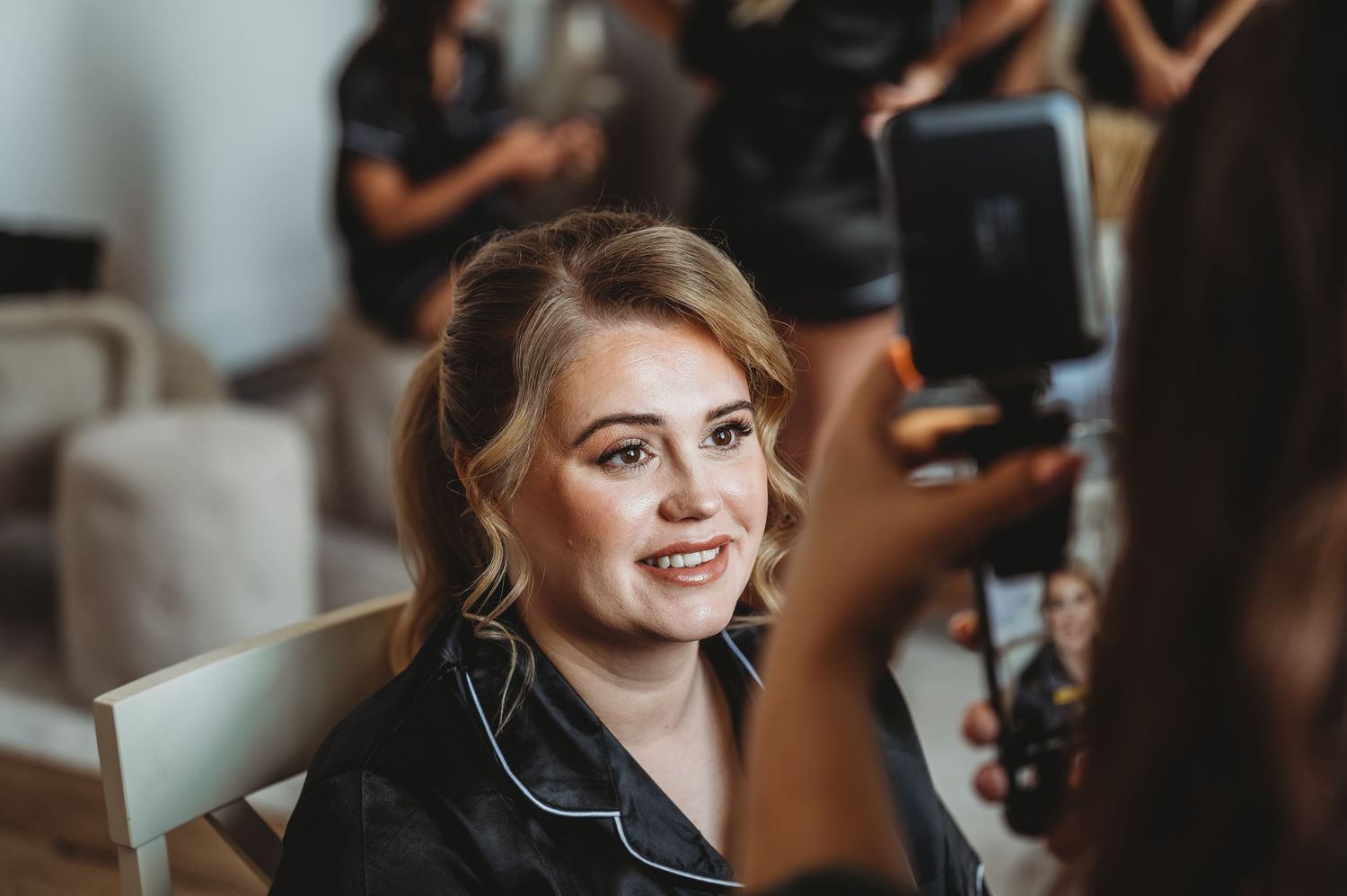 A candid moment of hair and makeup preparation being captured on camera.