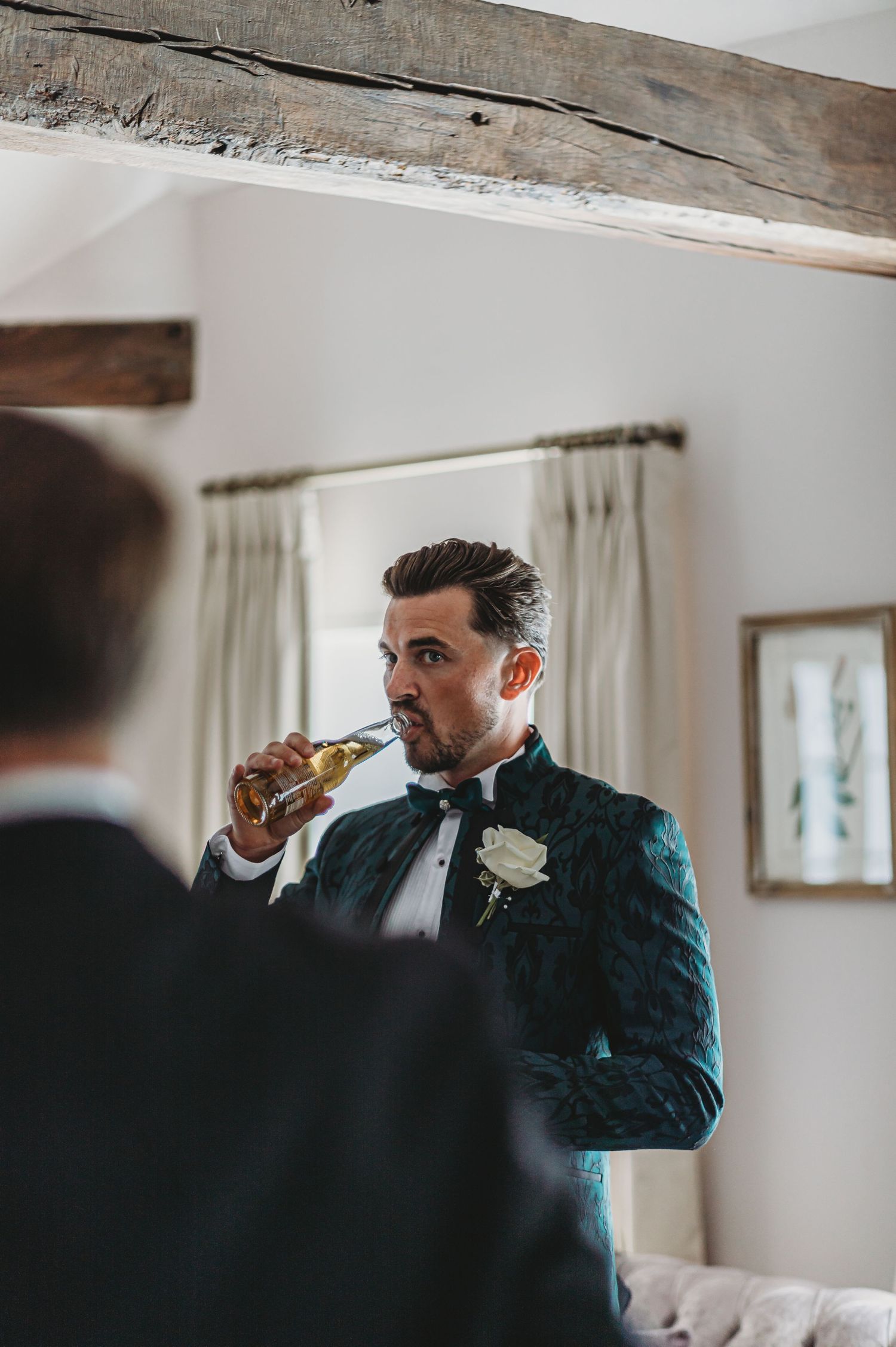 A toast moment captured indoors wearing dark velvet formal attire.