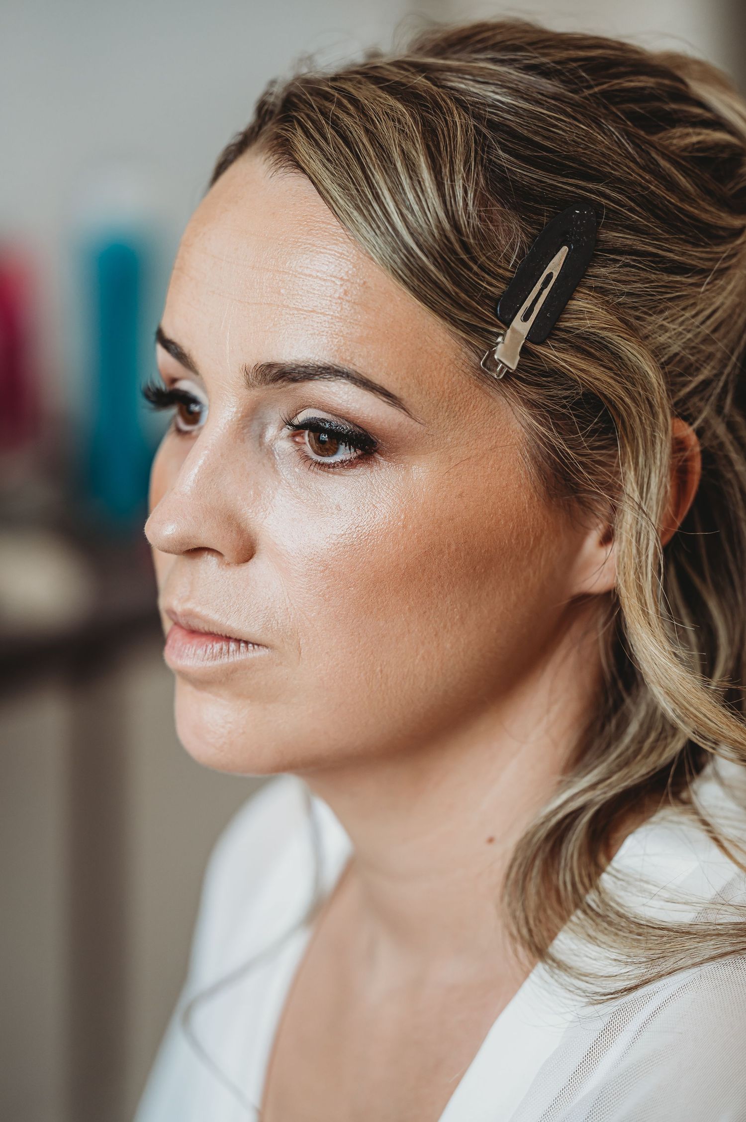 Close up of bridal makeup with soft glam eyeshadow and hair clips for styling.
