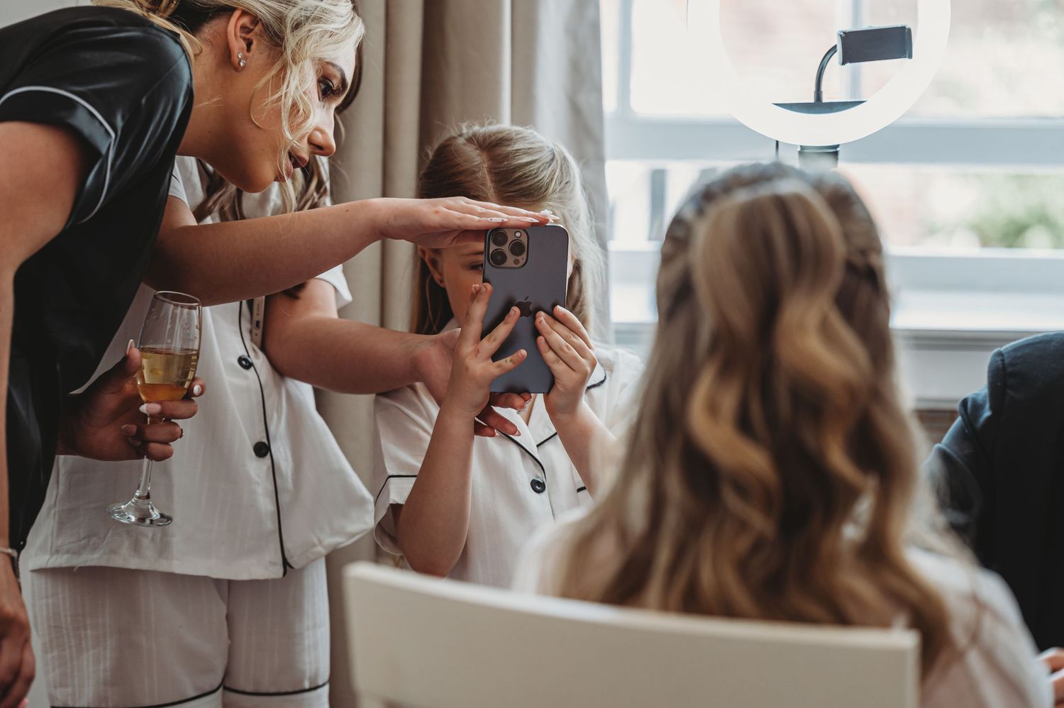 Wedding day preparations with people taking photos on phones while getting ready.