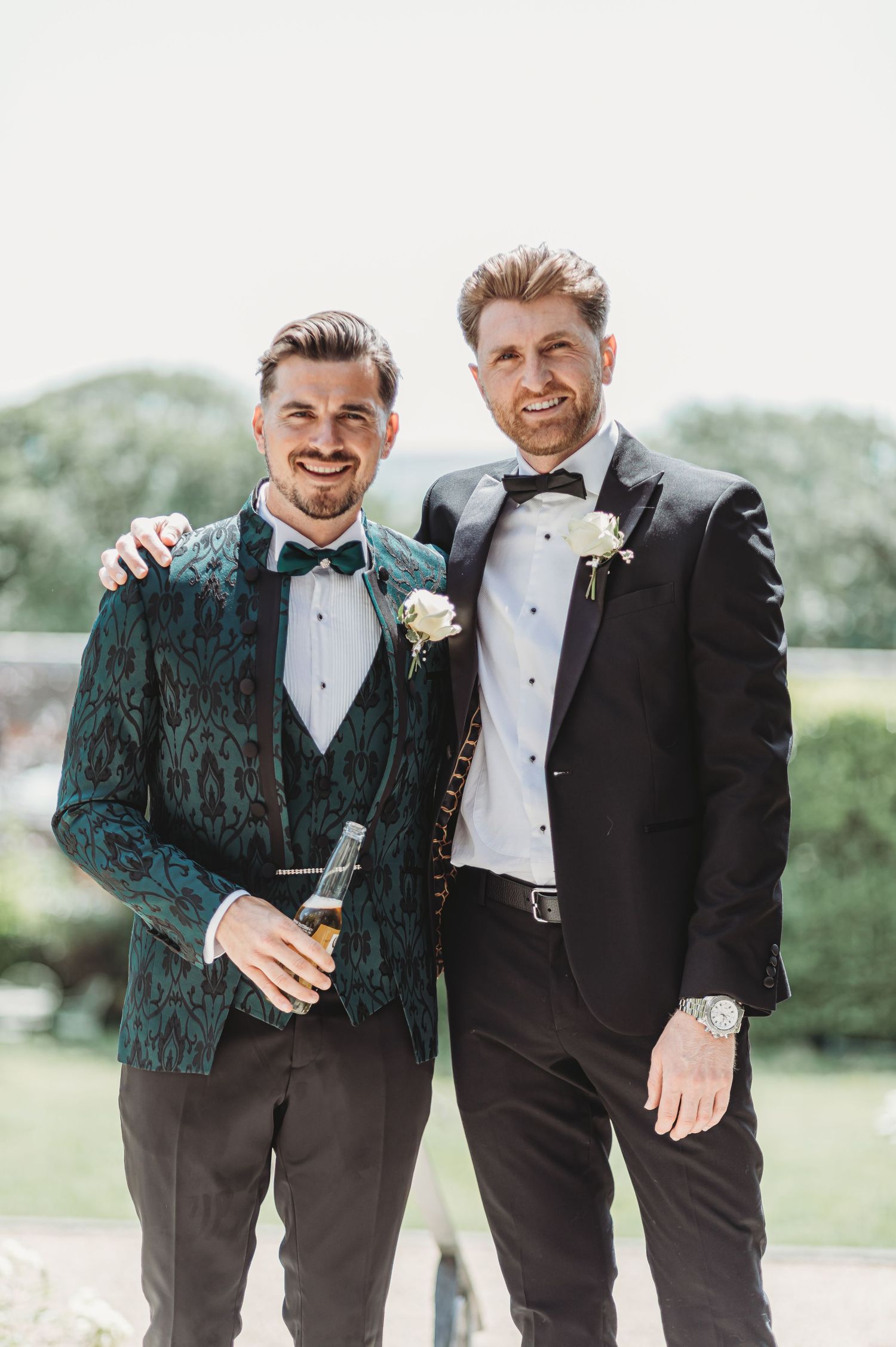 Two people in formal wear posing together, one wearing an elegant green velvet jacket.