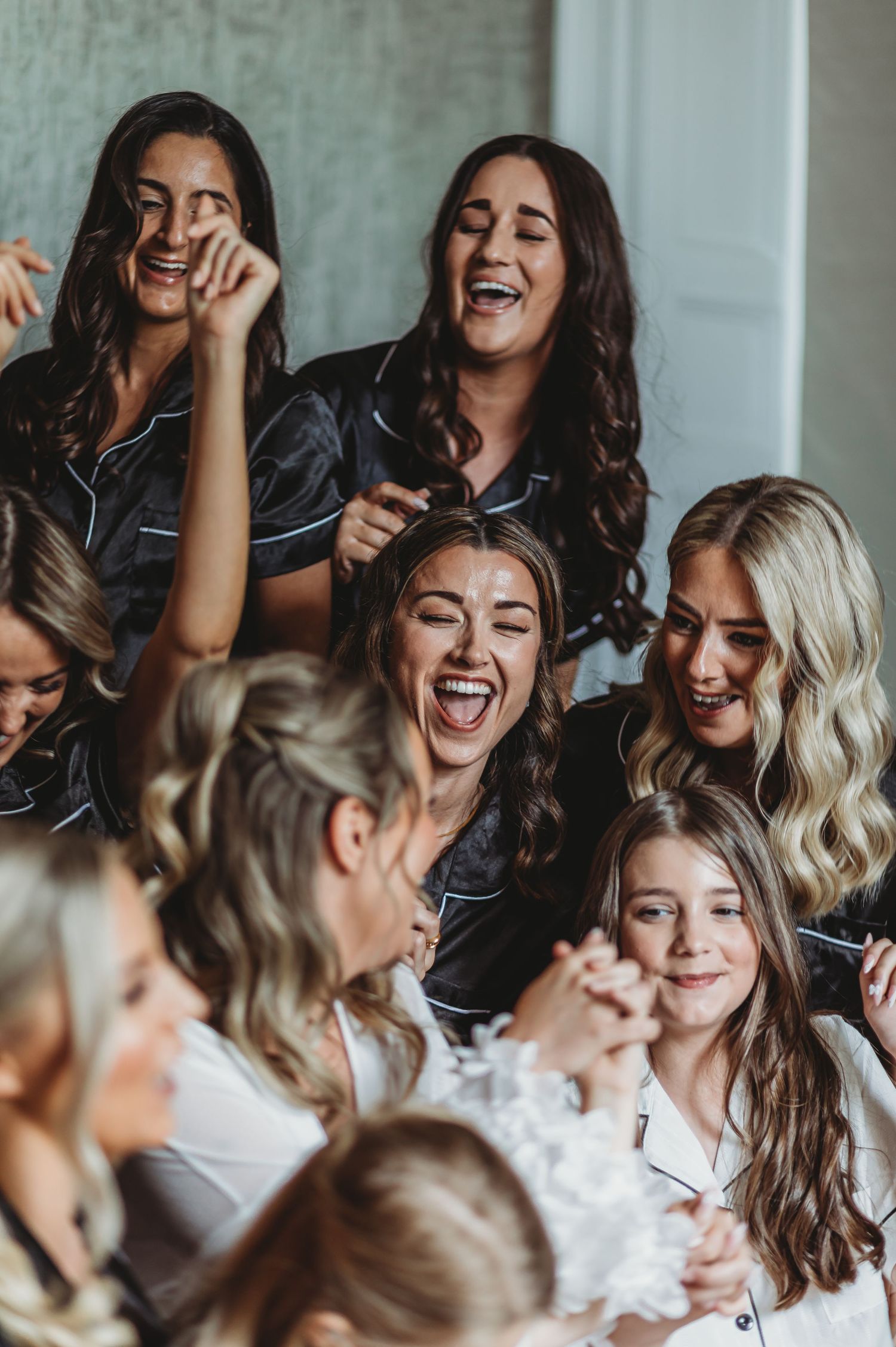 A candid moment capturing pure joy and laughter among a group dressed in black and white attire.