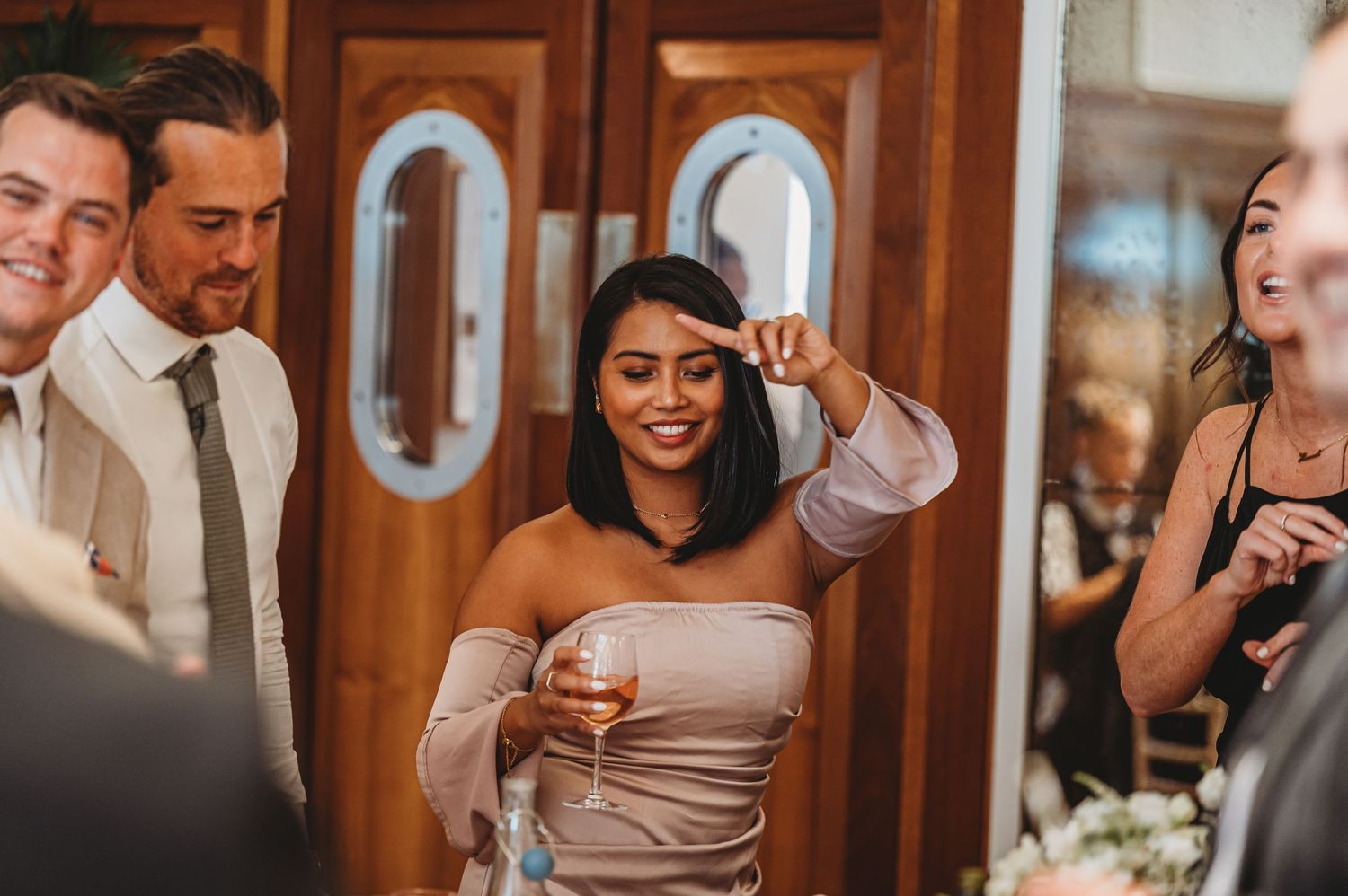 Wedding guests enjoying celebration and laughing together at reception.