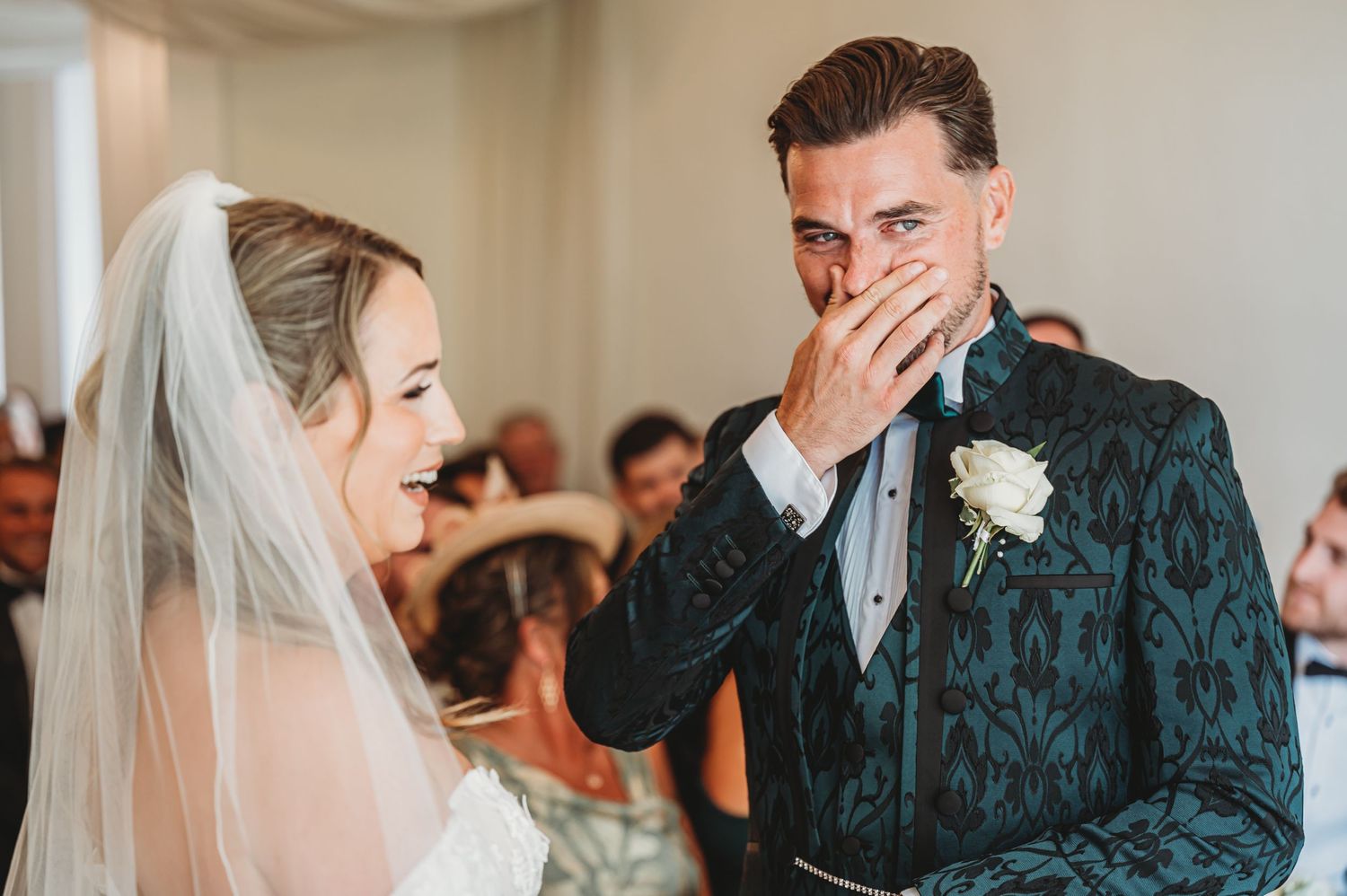 Emotional wedding moment in an indoor ceremony venue with elegant decor and natural lighting.