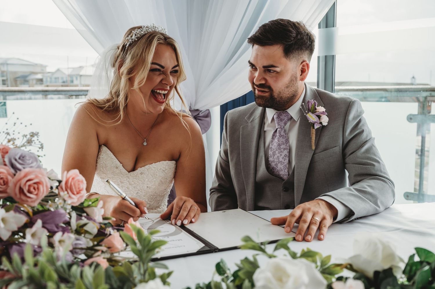 Candid moment of newlyweds completing paperwork at their wedding reception.