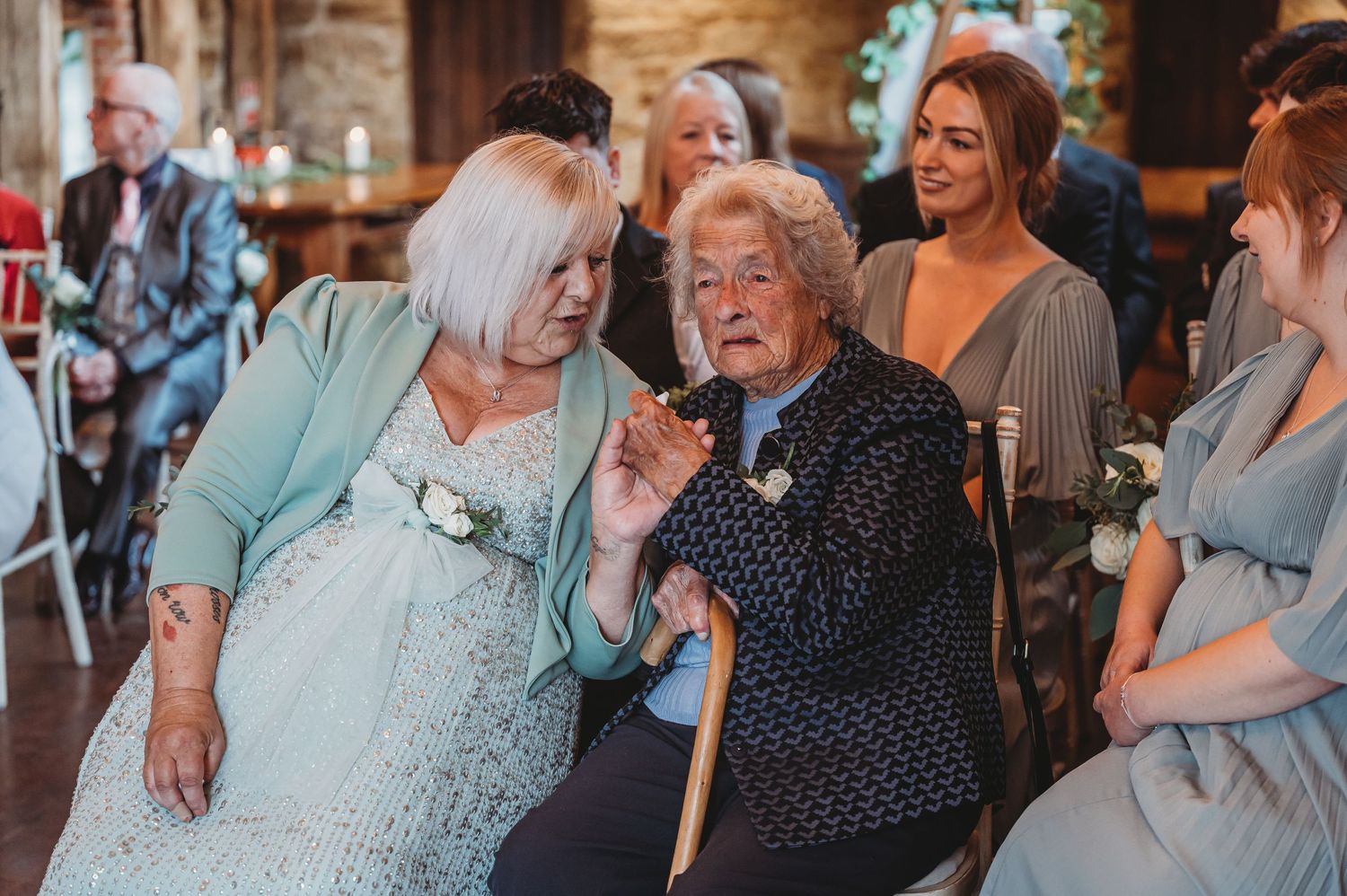 Elderly wedding guests share a lighthearted moment during the reception celebrations.