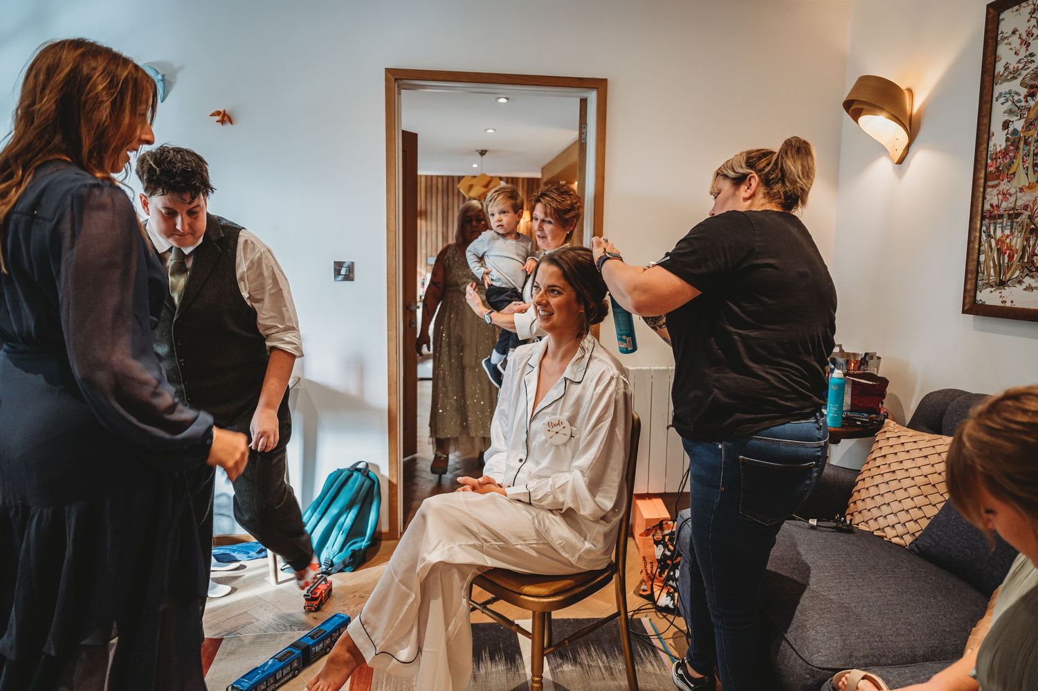 Candid scene from a wedding preparation day showing people getting ready in a cozy interior space.