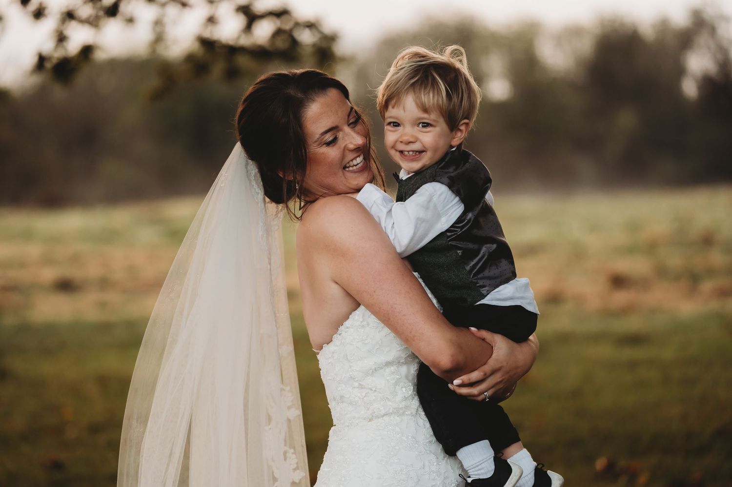 Joyful candid moment captured during outdoor wedding photography session.