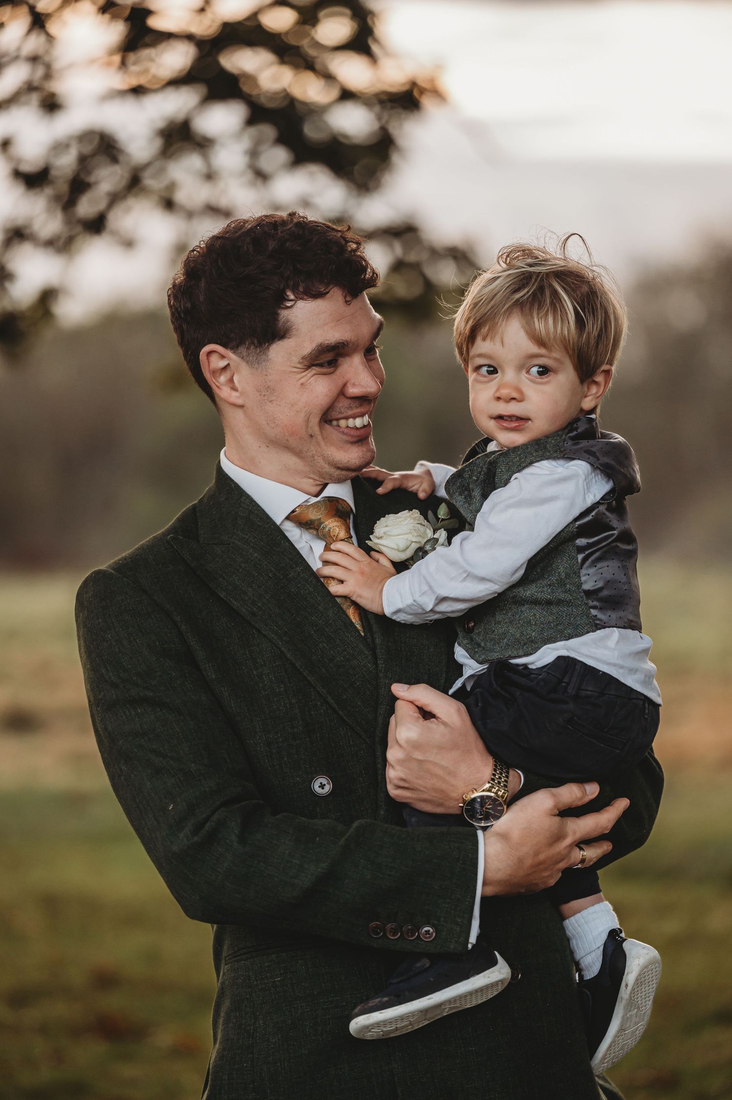 Sweet outdoor portrait at sunset featuring formal attire and joyful expressions.