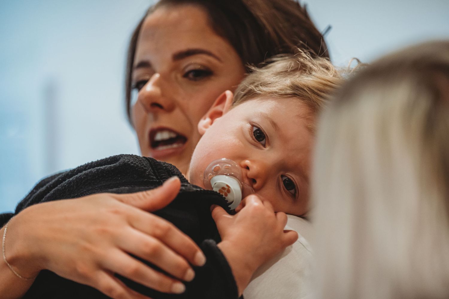 A candid moment showing a child being held while making a funny face.
