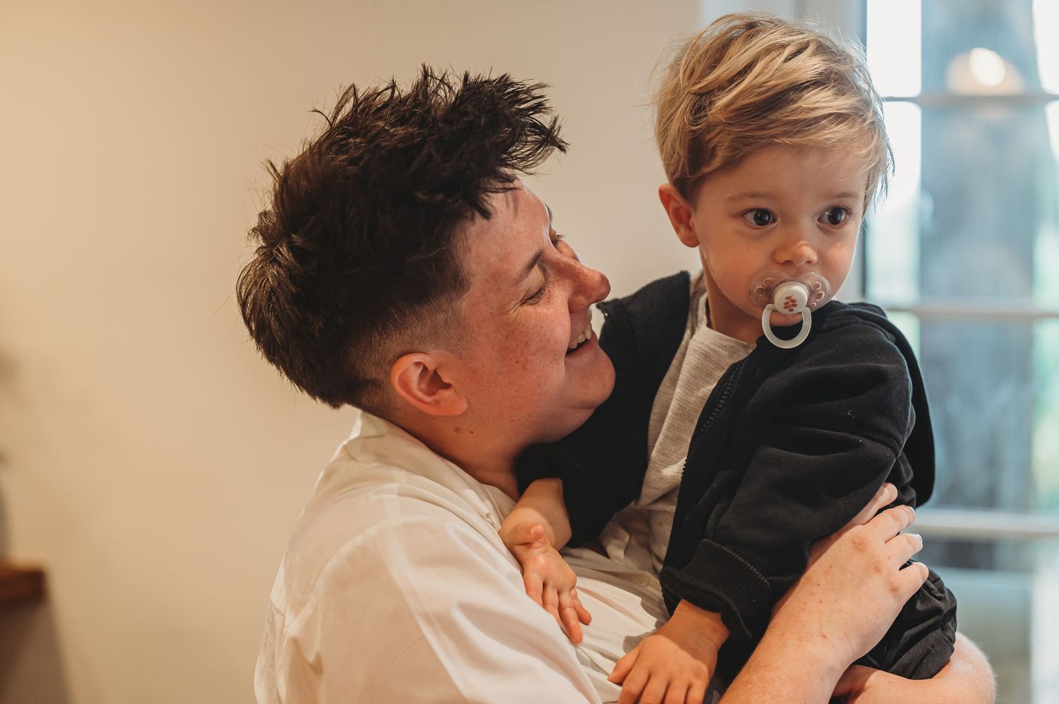 A heartwarming moment shared between a parent and young child in formal attire.