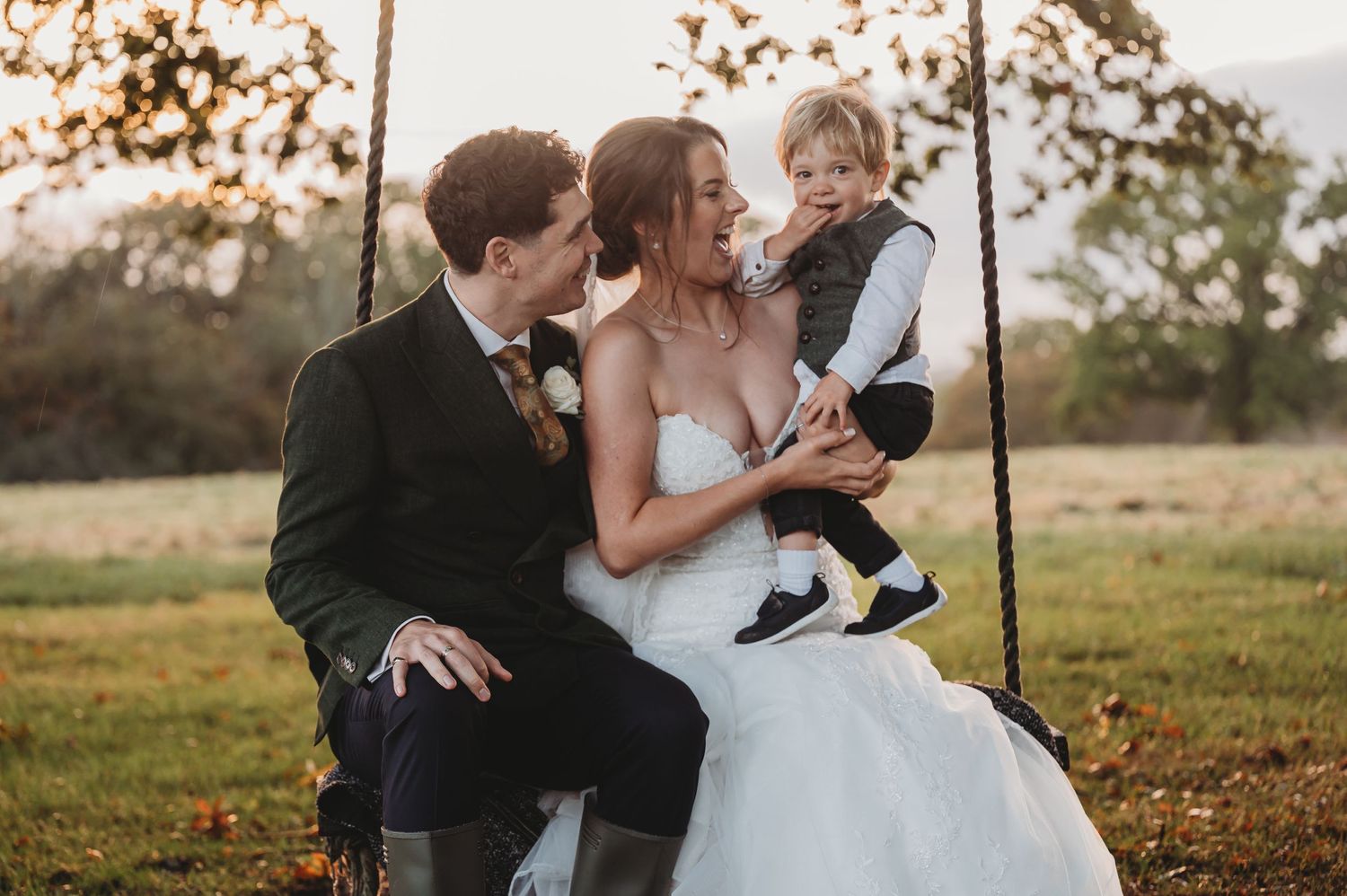 Natural wedding portrait on a swing during golden hour in an autumn setting.