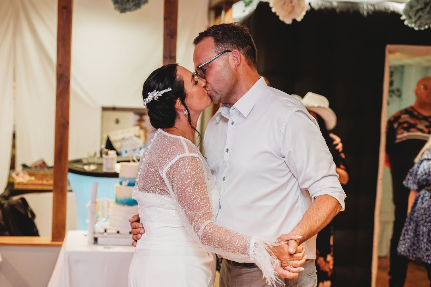 A couple shares a romantic dance together at their wedding reception, with the bride wearing a lace sleeve dress.