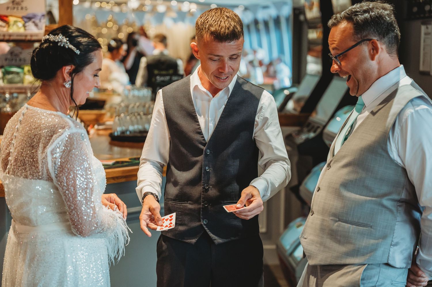 People in formal attire chat and laugh together at an elegant bar during a celebratory event.