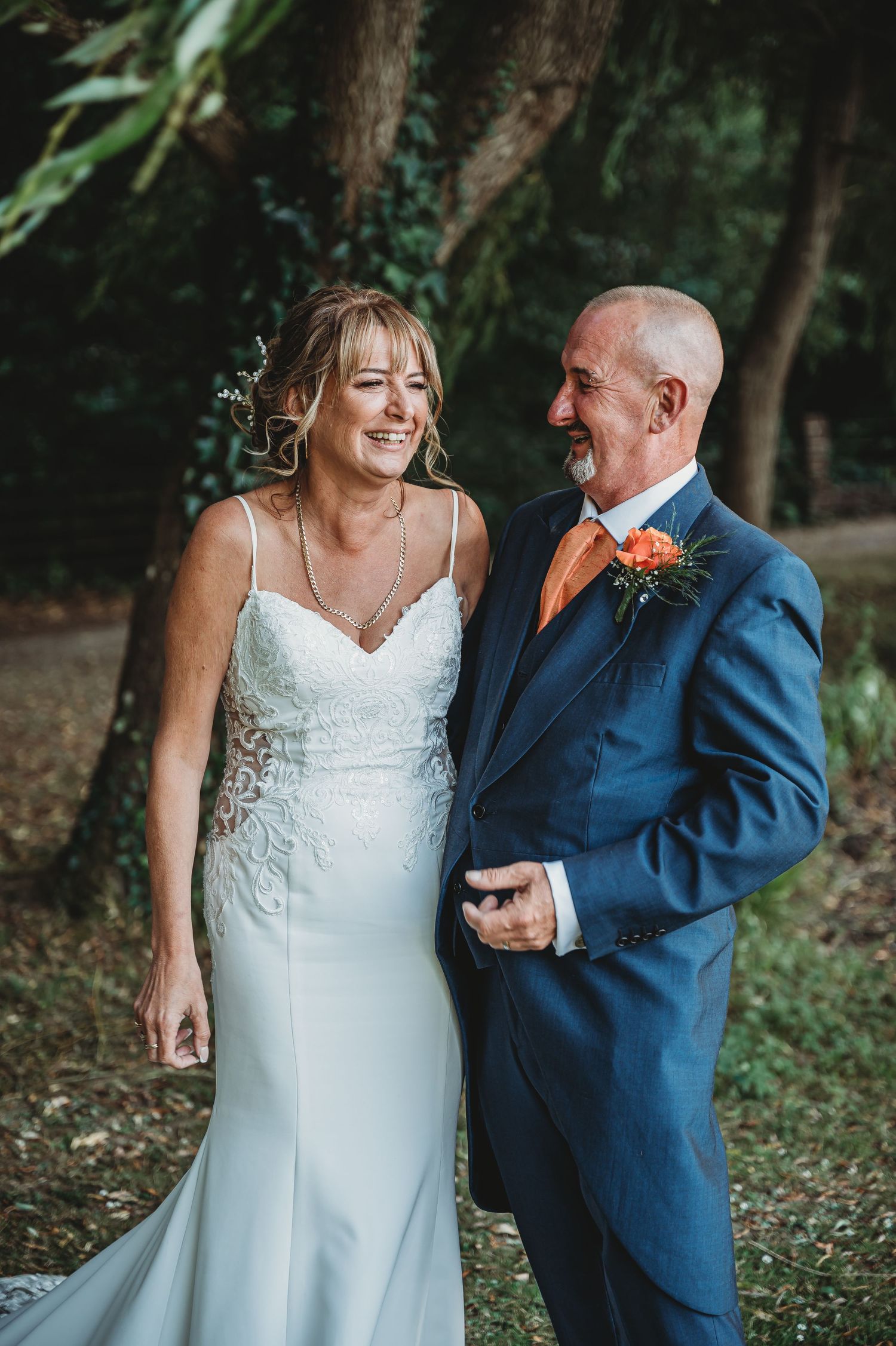 A happy couple shares a joyful moment together in a wooded setting during a wedding ceremony.