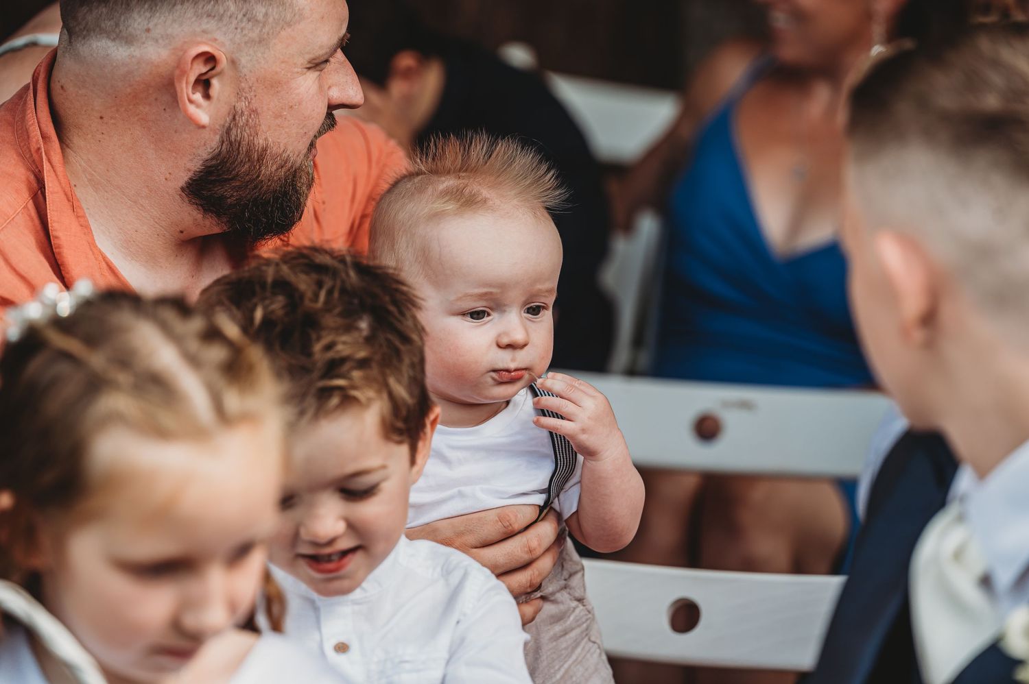 A small group watches attentively during a light-hearted moment at an outdoor gathering.