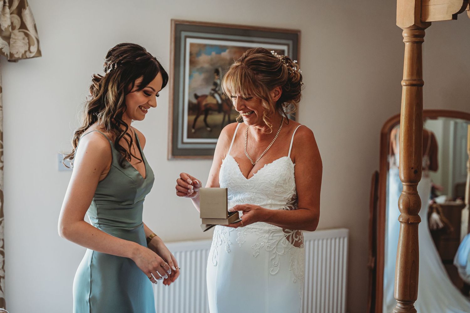 A tender moment during wedding preparations as two people share a quiet conversation in a sunlit room.