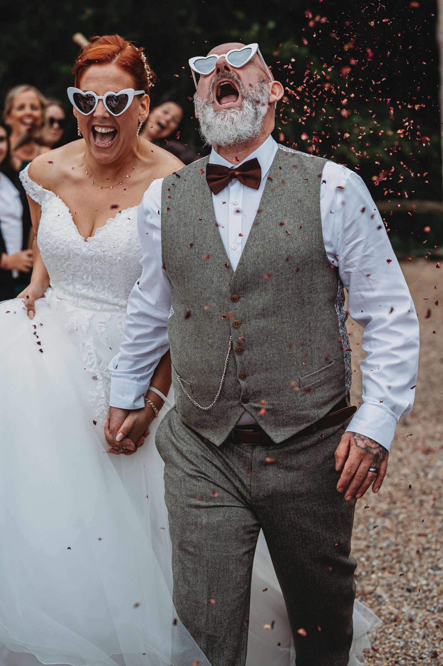 A joyous wedding celebration moment captured with confetti flying through the air as a couple shares laughter together.
