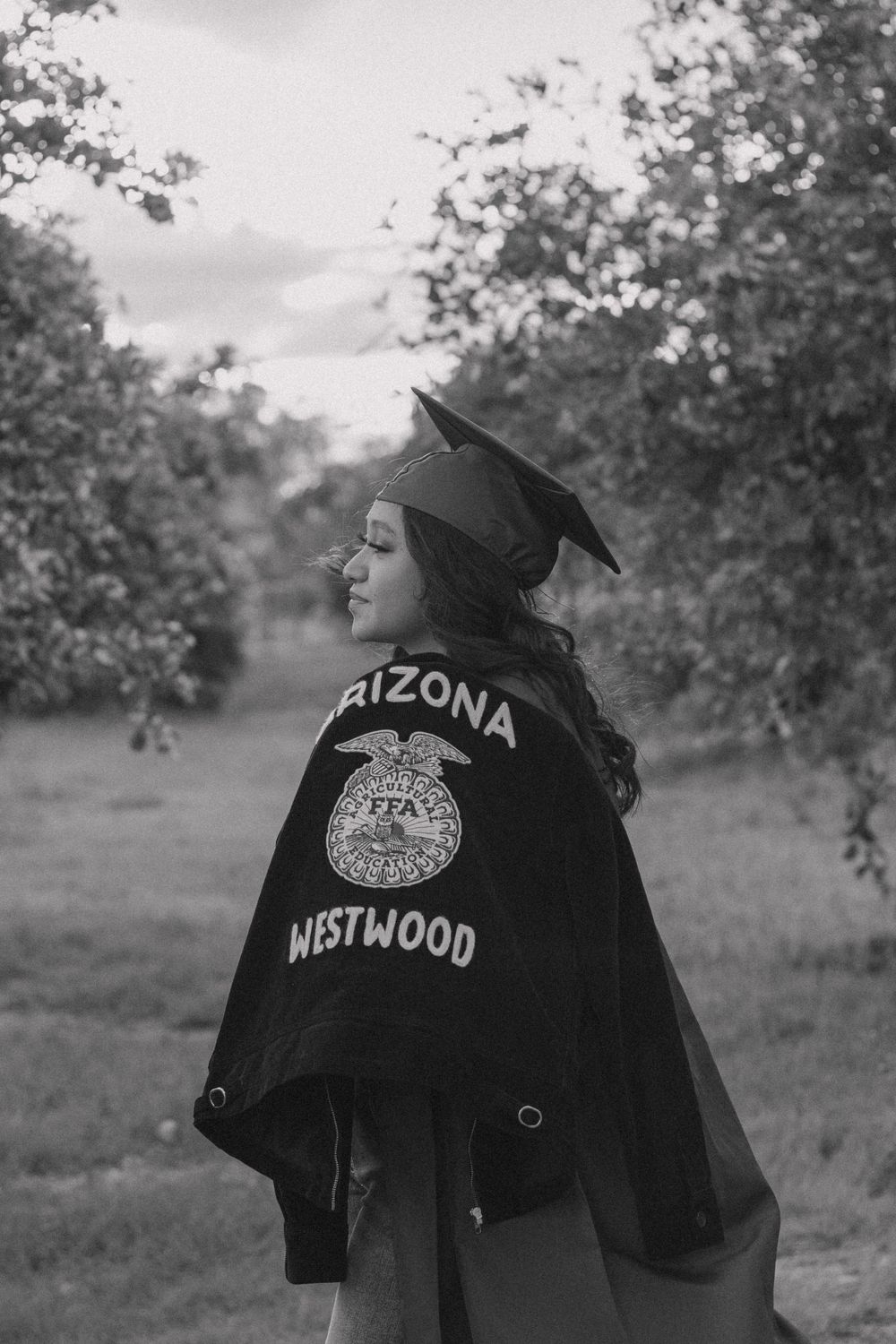 A graduation jacket with Arizona text shown from behind in black and white.