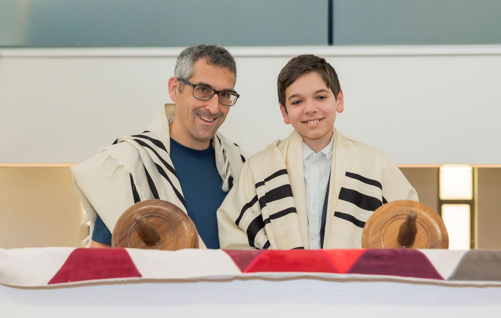 Religious ceremony participants wearing traditional prayer shawls at a synagogue service.