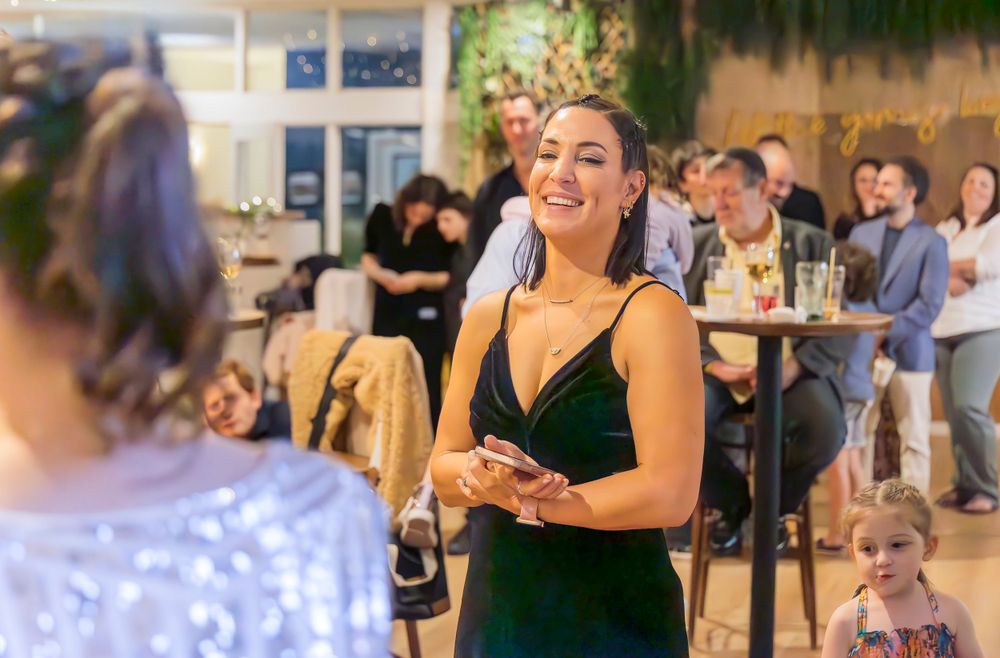 Person in a dark velvet dress smiling during a social gathering.