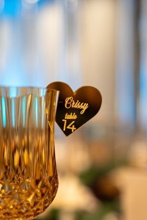 Crystal champagne glasses with gold heart-shaped table number markers for wedding reception.