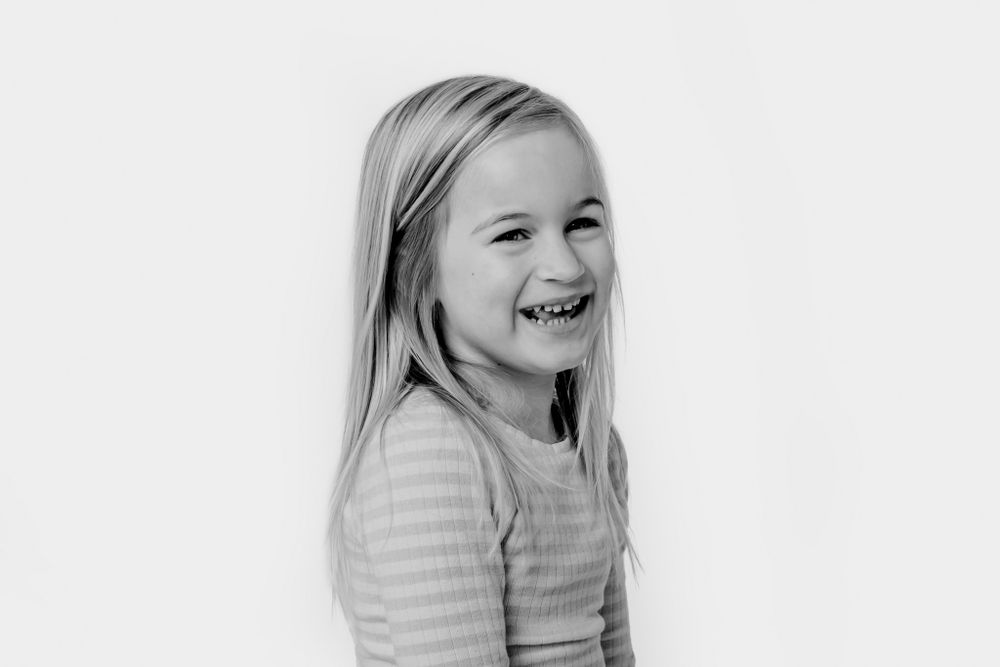 Børn i afslappet tøj, der viser ægte følelser i studiefotografi. Børnefotograf Fyn
