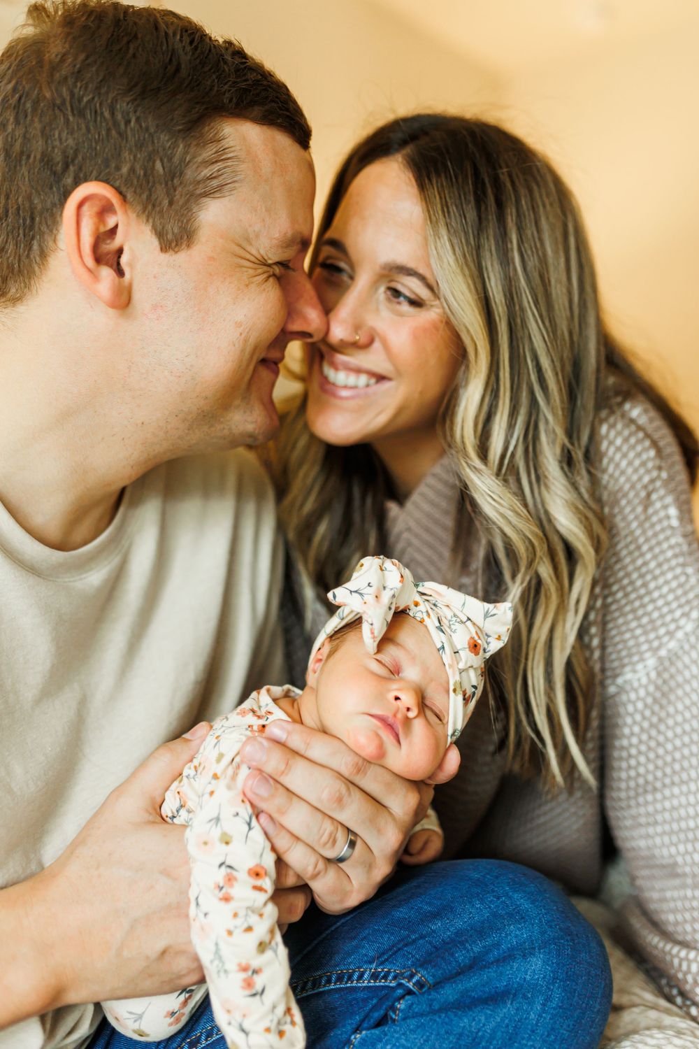 A couple shares tender moments while holding their newborn baby in a series of intimate lifestyle photos.