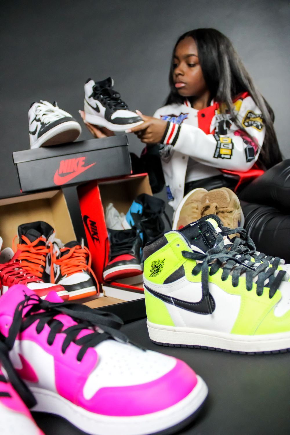 Collection of colorful Nike sneakers displayed with person examining footwear.
