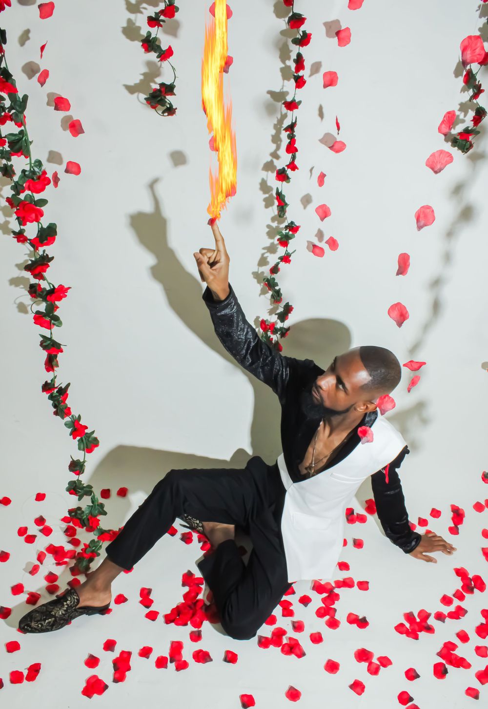 Dynamic photo of person reaching toward flame effect with rose petals scattered.