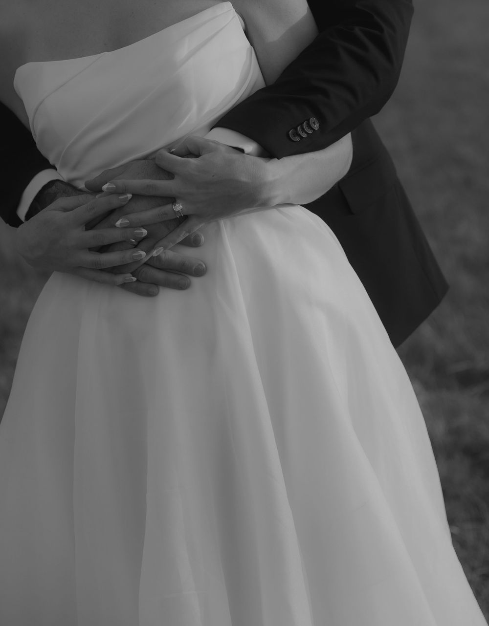 A series of black and white photos showing a couple embracing in formal wedding attire with focus on their hands and torsos.