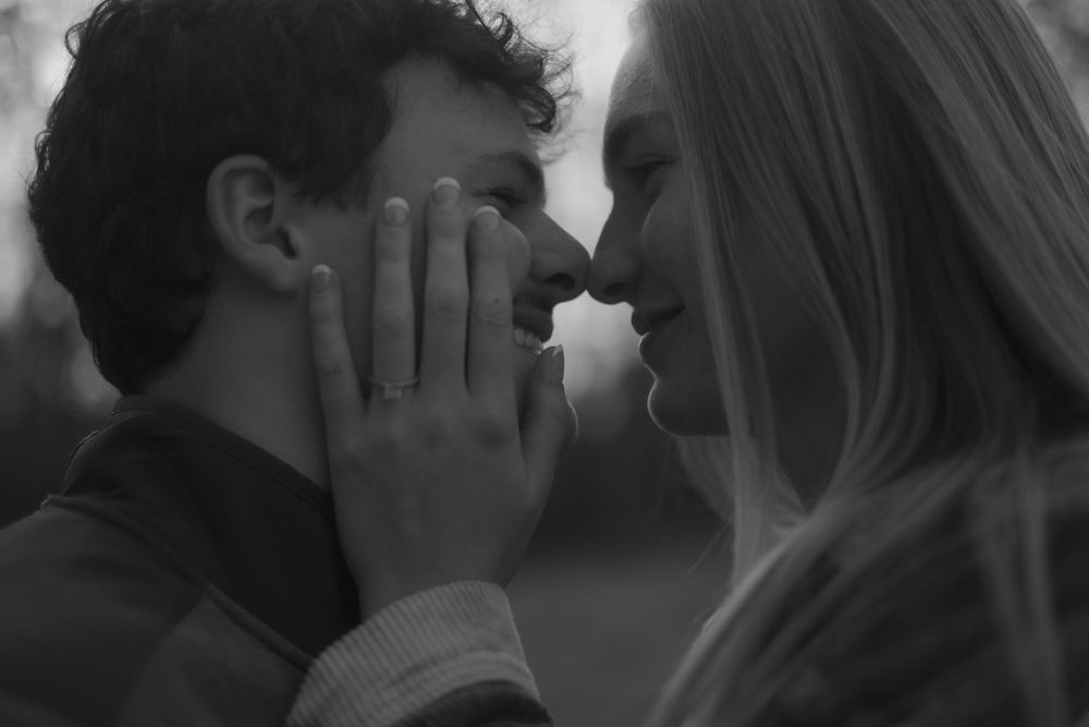 Black and white intimate close-up portrait of a romantic couple sharing a tender moment together.
