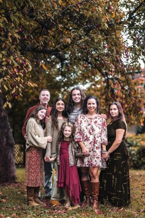 Group portrait under autumn trees with coordinated boho-style outfits in earth tones.