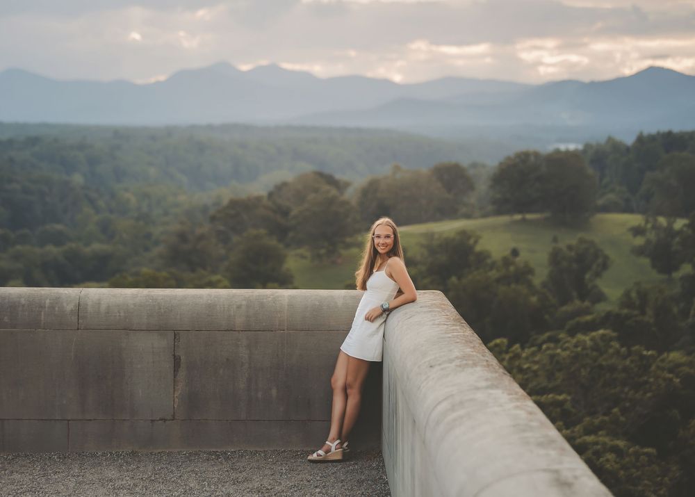 Scenic mountain landscape view with rolling hills and a concrete wall overlook during golden hour.
