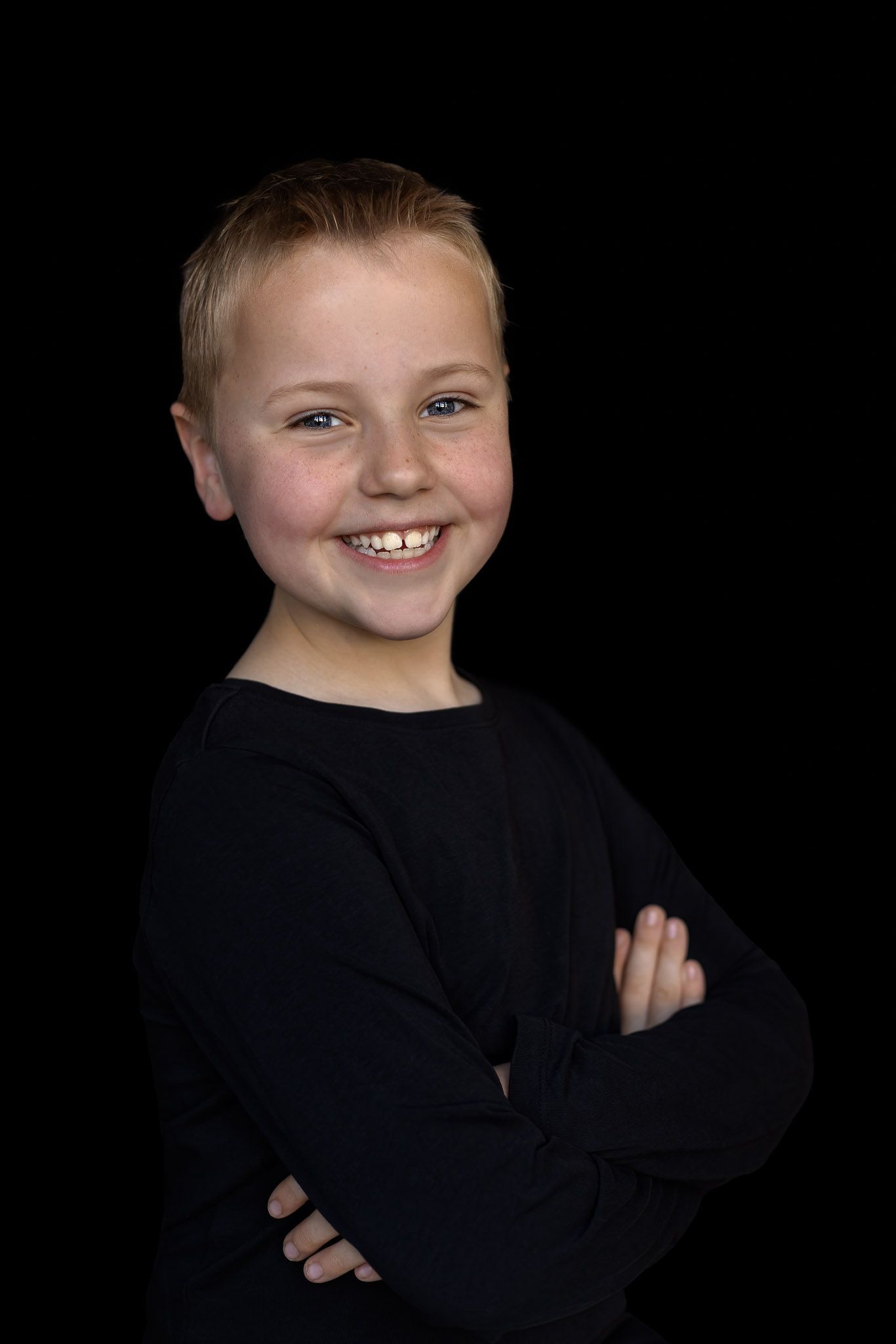 Barbara Kempeneers Fotografie, Kinderportret, Zwarte achtergrond, Stoere blonde jongen met lach